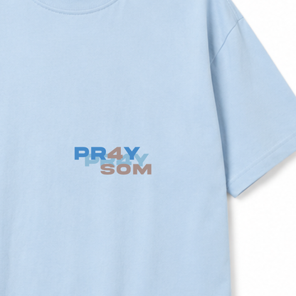 Detalle del print frontal «PR4Y SOM» en la camiseta celeste
